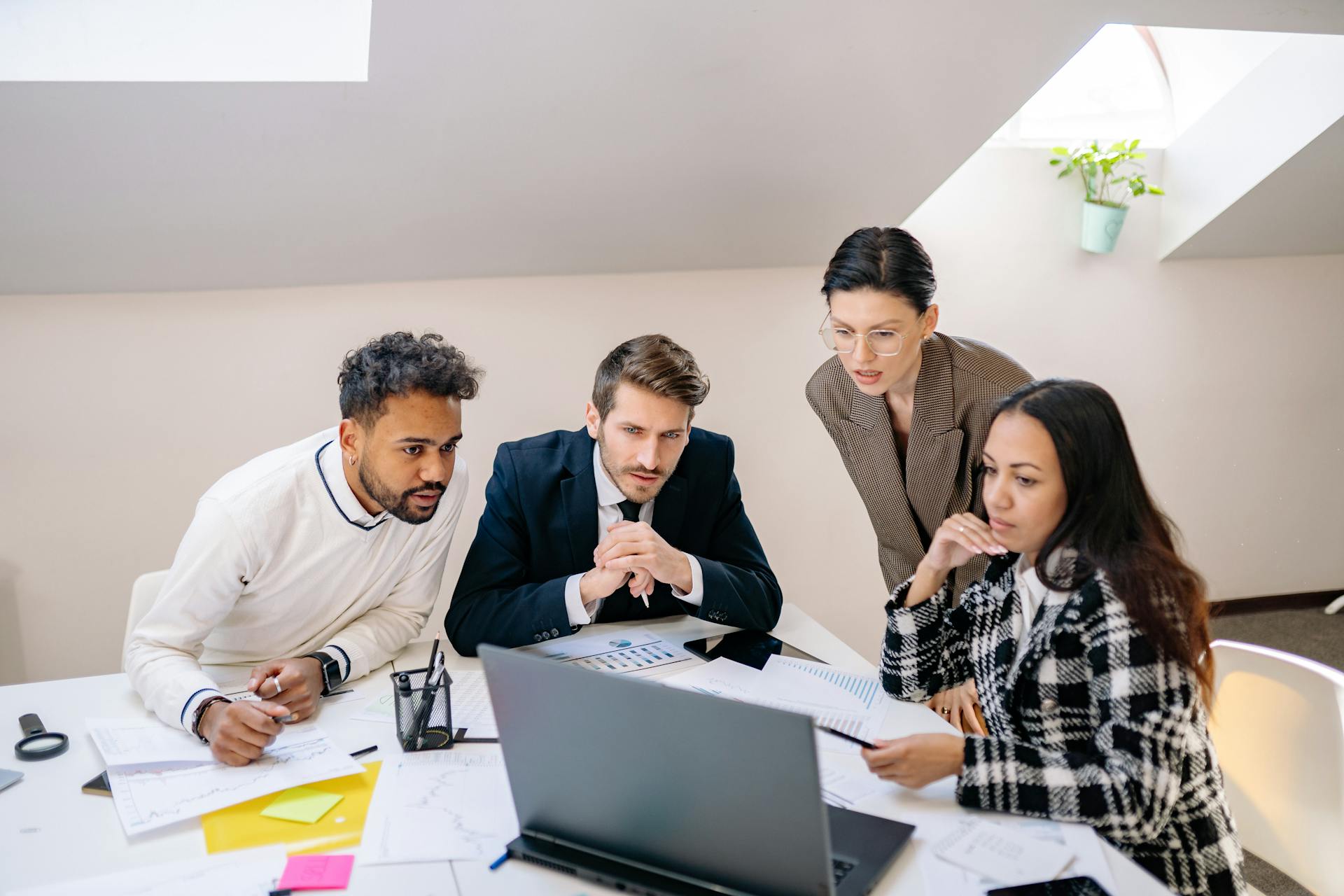 Team reviews website layout and call-to-action placement on a laptop screen